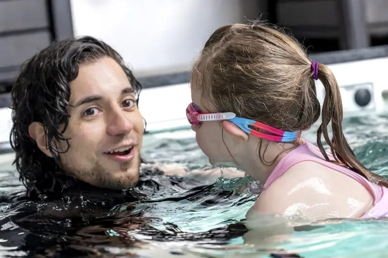 A SwimTec coach listens to a young swimmer during a private lesson in the Endless Pool