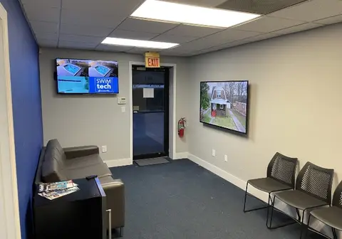 The seating area with wall-mounted screens at SwimTec Gainesville